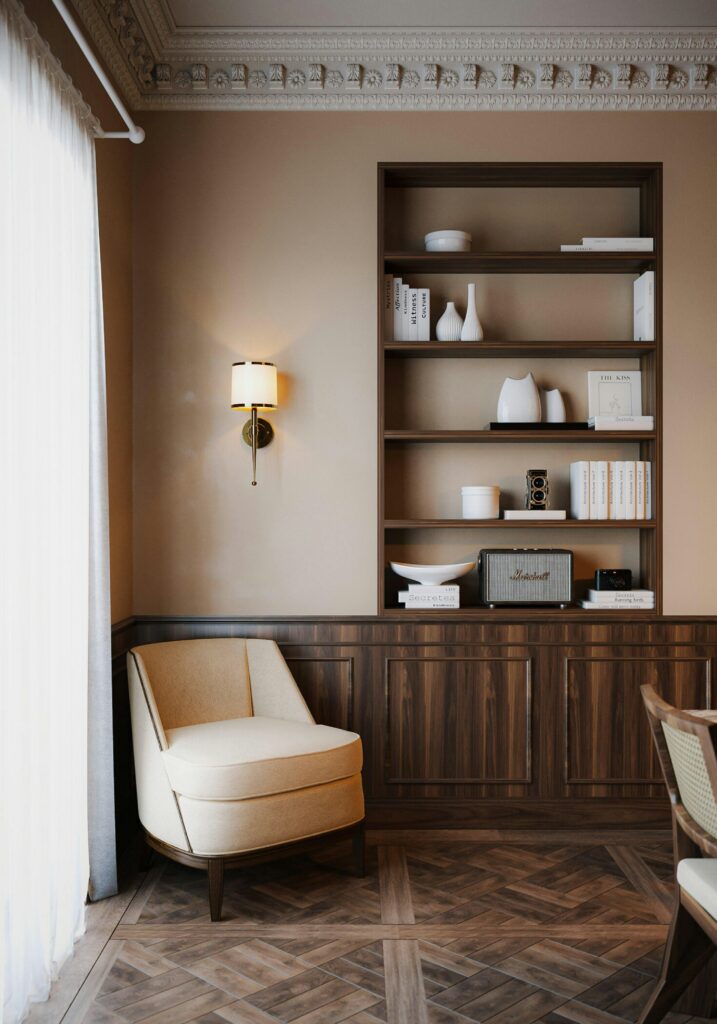 Elegant neutral-toned therapy room with armchair and shelving designed for calm, focused in-person psychotherapy sessions in Singapore
