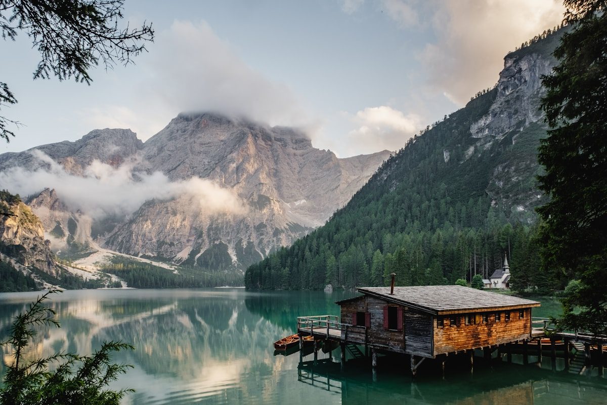 A still mountain lake with a wooden boathouse, evoking quiet steadiness and internal calm