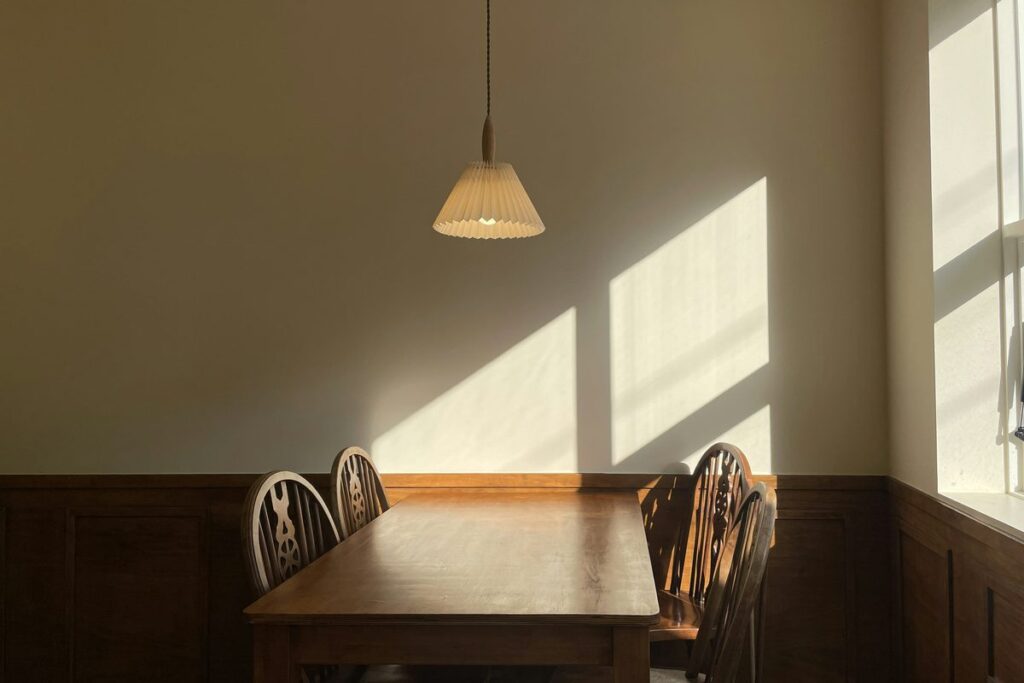 Warm morning sunlight on a simple wooden table, evoking calm, simplicity and nervous system regulation — Tidylodge Advanced-EMDR Intensives Singapore