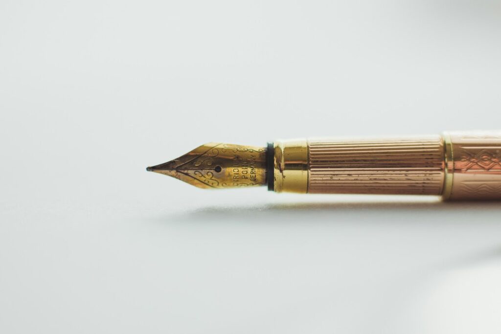 Brass pen resting on paper, symbolising that qualifications are tools, not the treatment itself