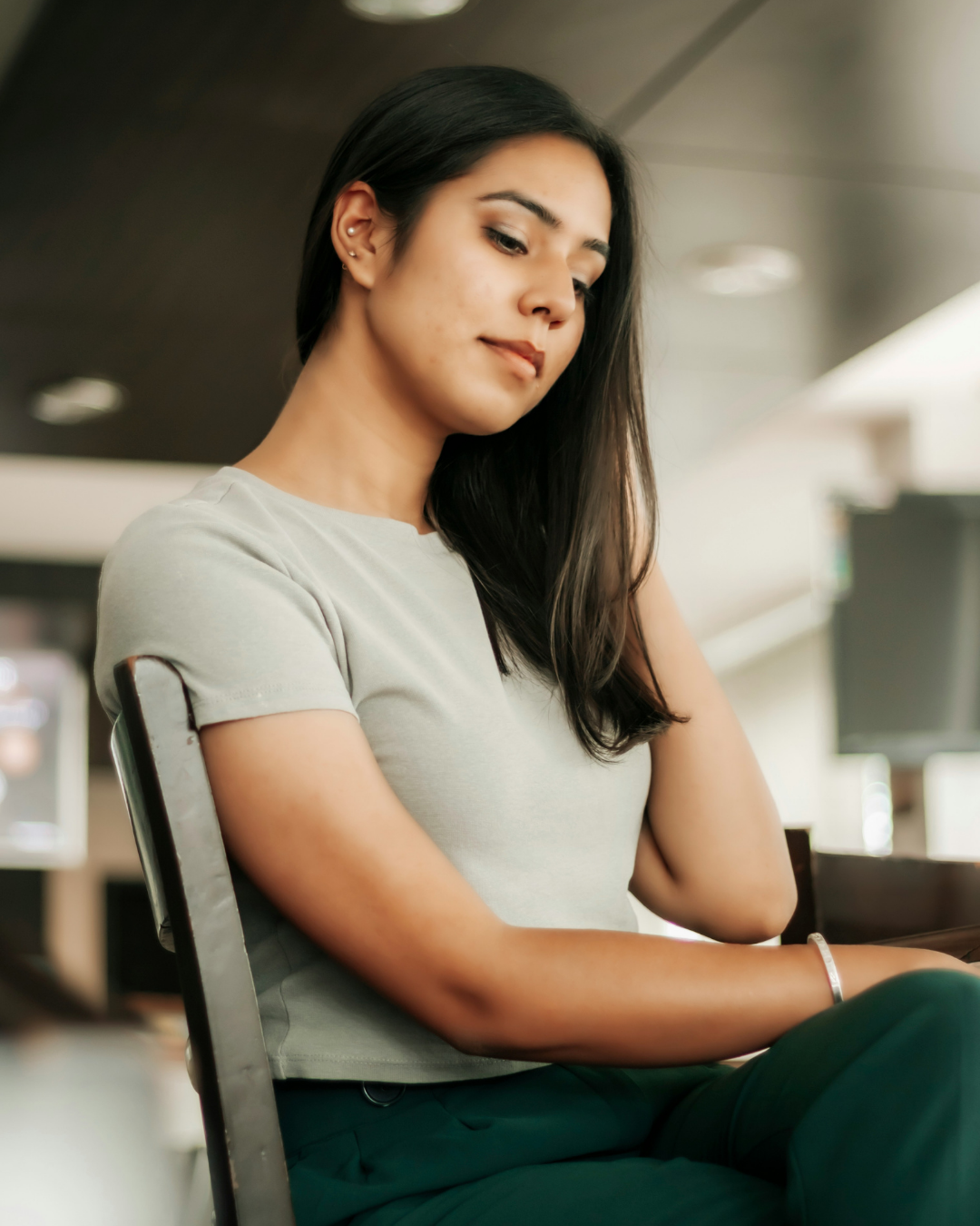 Woman sitting calmly and reflecting in a modern workspace